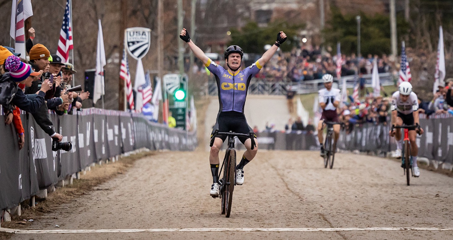 Cyclist crossing the finish line arms raised in victory